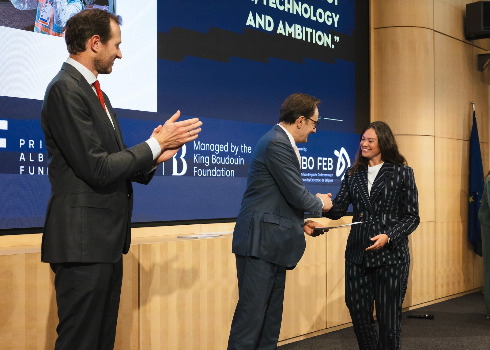 Julie Coorevits receiving the Prince Albert Fund laureate certificate on stage, managed by the King Baudouin Foundation and VBO FEB